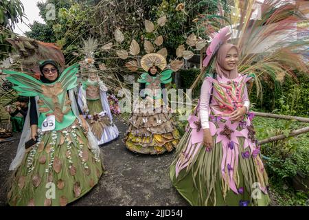 Bogor, Indonesien. 24.. Juli 2022. Eine Frau im Naturkleid aus Blättern, Blumen und Wurzeln nimmt am 24. Juli 2022 an einer Naturmodeparade 'Zurück zur Kulturerhaltung der Natur' in Bogor, West Java, Indonesien Teil. (Foto von Andi M Ridwan/INA Photo Agency/Sipa USA) Quelle: SIPA USA/Alamy Live News Stockfoto