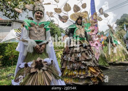 Bogor, Indonesien. 24.. Juli 2022. Eine Frau im Naturkleid aus Blättern, Blumen und Wurzeln nimmt am 24. Juli 2022 an einer Naturmodeparade 'Zurück zur Kulturerhaltung der Natur' in Bogor, West Java, Indonesien Teil. (Foto von Andi M Ridwan/INA Photo Agency/Sipa USA) Quelle: SIPA USA/Alamy Live News Stockfoto