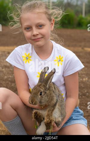 Kaninchen Sommertag Mädchen im Freien kleine weiße Hase ostern spielen, aus glücklicher Kindheit für Gras für Pelzfarm, Familie Ohren. Der Zoo ist schön, Stockfoto