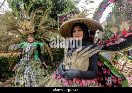 Bogor, Indonesien. 24.. Juli 2022. Eine Frau im Naturkleid aus Blättern, Blumen und Wurzeln nimmt am 24. Juli 2022 an einer Naturmodeparade 'Zurück zur Kulturerhaltung der Natur' in Bogor, West Java, Indonesien Teil. (Foto von Andi M Ridwan/INA Photo Agency/Sipa USA) Quelle: SIPA USA/Alamy Live News Stockfoto