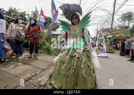 Bogor, Indonesien. 24.. Juli 2022. Eine Frau im Naturkleid aus Blättern, Blumen und Wurzeln nimmt am 24. Juli 2022 an einer Naturmodeparade 'Zurück zur Kulturerhaltung der Natur' in Bogor, West Java, Indonesien Teil. (Foto von Andi M Ridwan/INA Photo Agency/Sipa USA) Quelle: SIPA USA/Alamy Live News Stockfoto