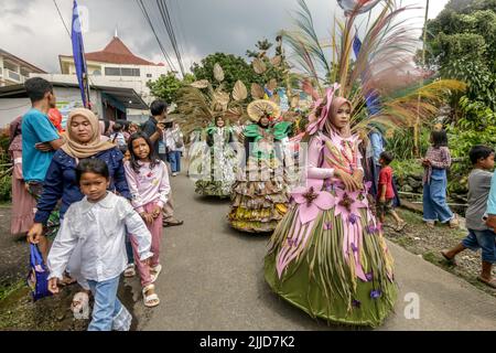 Bogor, Indonesien. 24.. Juli 2022. Eine Frau im Naturkleid aus Blättern, Blumen und Wurzeln nimmt am 24. Juli 2022 an einer Naturmodeparade 'Zurück zur Kulturerhaltung der Natur' in Bogor, West Java, Indonesien Teil. (Foto von Andi M Ridwan/INA Photo Agency/Sipa USA) Quelle: SIPA USA/Alamy Live News Stockfoto