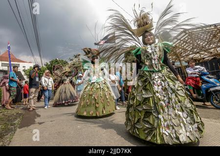 Bogor, Indonesien. 24.. Juli 2022. Eine Frau im Naturkleid aus Blättern, Blumen und Wurzeln nimmt am 24. Juli 2022 an einer Naturmodeparade 'Zurück zur Kulturerhaltung der Natur' in Bogor, West Java, Indonesien Teil. (Foto von Andi M Ridwan/INA Photo Agency/Sipa USA) Quelle: SIPA USA/Alamy Live News Stockfoto