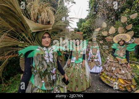 Bogor, Indonesien. 24.. Juli 2022. Eine Frau im Naturkleid aus Blättern, Blumen und Wurzeln nimmt am 24. Juli 2022 an einer Naturmodeparade 'Zurück zur Kulturerhaltung der Natur' in Bogor, West Java, Indonesien Teil. (Foto von Andi M Ridwan/INA Photo Agency/Sipa USA) Quelle: SIPA USA/Alamy Live News Stockfoto