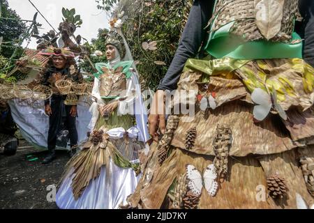 Bogor, Indonesien. 24.. Juli 2022. Eine Frau im Naturkleid aus Blättern, Blumen und Wurzeln nimmt am 24. Juli 2022 an einer Naturmodeparade 'Zurück zur Kulturerhaltung der Natur' in Bogor, West Java, Indonesien Teil. (Foto von Andi M Ridwan/INA Photo Agency/Sipa USA) Quelle: SIPA USA/Alamy Live News Stockfoto