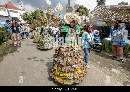 Bogor, Indonesien. 24.. Juli 2022. Eine Frau im Naturkleid aus Blättern, Blumen und Wurzeln nimmt am 24. Juli 2022 an einer Naturmodeparade 'Zurück zur Kulturerhaltung der Natur' in Bogor, West Java, Indonesien Teil. (Foto von Andi M Ridwan/INA Photo Agency/Sipa USA) Quelle: SIPA USA/Alamy Live News Stockfoto