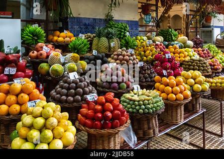 FUNCHAL, PORTUGAL - 24. AUGUST 2021: Dies ist ein Stall auf dem Bauernmarkt voller tropischer Früchte. Stockfoto