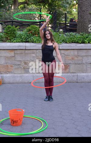 Miss 360, eine Straßenkünstlerin, die mit Hula Hoops arbeitet, tritt im Union Square Park in New York City auf Stockfoto