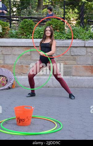 Miss 360, eine Straßenkünstlerin, die mit Hula Hoops arbeitet, tritt im Union Square Park in New York City auf Stockfoto