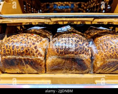 Unmarkierte, in Plastik verpackte Brotscheiben stehen auf einem Supermarktregal, das verkauft werden kann Stockfoto