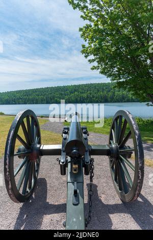 Historische schwarze Pulverkanone, die über einer Küstenlinie wacht Stockfoto