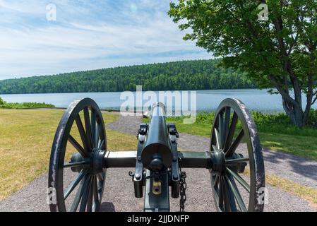 Historische schwarze Pulverkanone, die über einer Küstenlinie wacht Stockfoto