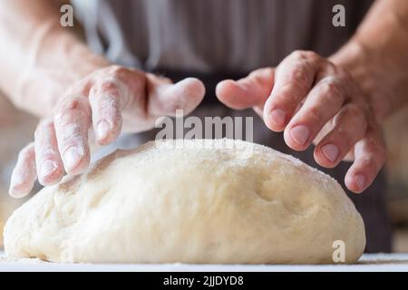 Brotbackwaren Essen kulinarischer Mann Hände kneten Teig Stockfoto