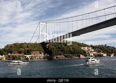 Blick auf Yachten, die am Bosporus durch das Kanlica-Viertel auf der asiatischen Seite Istanbuls vorbeifahren. Die FSM-Brücke ist im Hintergrund. Es ist ein sonniger Sommertag. Beau Stockfoto