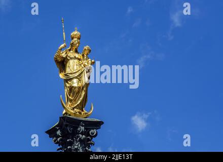 Die Statue der Mariensäule auf dem Marienplatz in München. Die Mariensäule ist eine goldfarbene Statue, die die Madonna mit dem Jesuskind auf einem steht Stockfoto