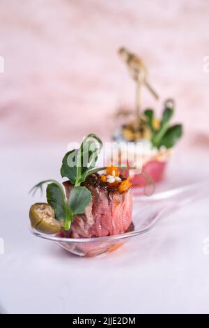 Bruschetta ein Stück geschmortes Rindfleisch auf einem Plastiklöffel. Stockfoto