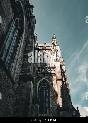 Eine Nahaufnahme der Kirche St. Peter und St. Paul unter Sonnenlicht in Ostend, Belgien. Der Tanz von Schatten und Licht über der historischen Kirche. Stockfoto