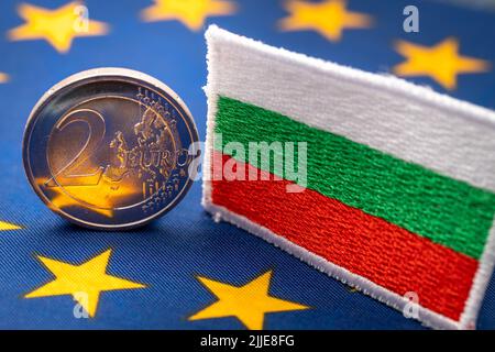 Die Flagge Bulgariens vor dem Hintergrund der einheitlichen Währung der Europäischen Union, das Konzept des Beitritts Bulgariens zur Euro-Zone, wirtschaftliche und Stockfoto