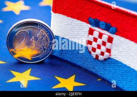 Die Flagge Kroatiens vor dem Hintergrund der einheitlichen Währung der Europäischen Union, das Konzept des Beitritts Kroatiens zur Euro-Zone, Wirtschafts- und Stockfoto