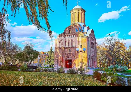 Der grüne Rasen, bedeckt mit gelben Birkenblättern, vor der Kirche St. Paraskeva (Pjatnytska), Tschernihiw, Ukraine Stockfoto