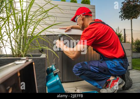 Kaukasisch Professional Whirlpools Technician Finishing Garden SPA Installation in Wohn Garten Garten. Stockfoto