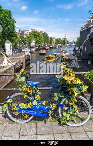 Sint Antoniesluis, auf dem Oudeschans-Kanal, Fahrrad mit Sonnenblumen geschmückt, Grachtenrundfahrt, Café, De Sluyswacht, Amsterdam, Niederlande Stockfoto