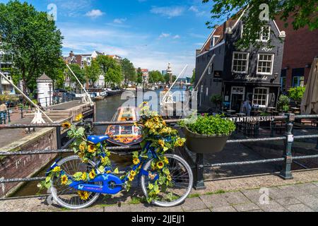Sint Antoniesluis, auf dem Oudeschans-Kanal, Fahrrad mit Sonnenblumen geschmückt, Grachtenrundfahrt, Café, De Sluyswacht, Amsterdam, Niederlande Stockfoto