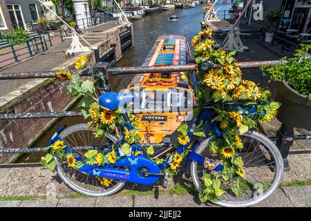 Sint Antoniesluis, auf dem Oudeschans-Kanal, Fahrrad mit Sonnenblumen geschmückt, Grachtenrundfahrt, Café, De Sluyswacht, Amsterdam, Niederlande Stockfoto