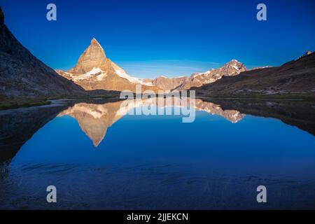 Matterhorn bei goldenem Sonnenaufgang am Riffelsee, Zermatt, Schweiz Stockfoto