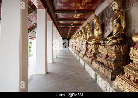 Reihe von buddha-Statuen entlang des Korridors des Wat Suthat Thepwararam Ratchaworahawihan Tempels in Bangkok, Thailand Stockfoto