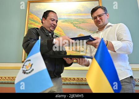 Kiew, Ukraine. 25.. Juli 2022. Der ukrainische Außenminister Dmytro Kuleba, rechts, und der guatemaltekische Außenminister Mario Bucaro, links, tauschen im Mariinskyi-Palast am 25. Juli 2022 in Kiew, Ukraine, Kopien eines unterzeichneten Abkommens über die Befreiung von der Visumpflicht aus. Kredit: Ukrainisches Presidential Press Office/Ukraine Presidency/Alamy Live News Stockfoto