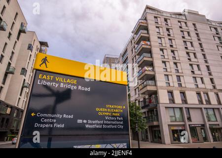 Straßenschild und Wohnungen in London im East Village, ehemaliges Athletes Village, 2012 Olympische Spiele, E20 Postleitzahl, Stratford, Newham, London, Großbritannien. Stockfoto