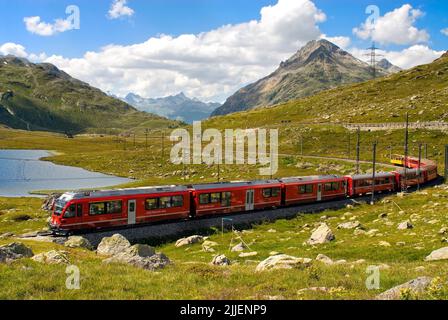 Zug des Rhätischen Zuges am Lago Bianco am Bernina Pass, Schweizer Alpen, Schweiz Stockfoto