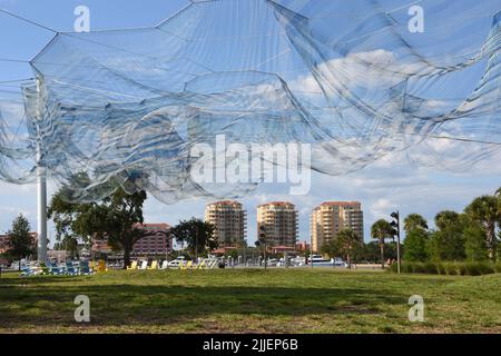 Die Faserskulptur des Biegungsbogens auf dem Spielplatz der Grazer Family während des Tages mit drei hohen Gebäuden im Hintergrund, St. Petersburg, Florida. Stockfoto