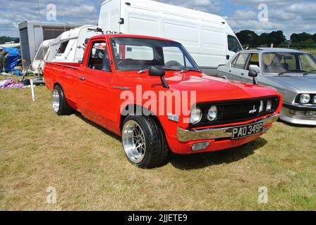 Ein 1976 Datsun 1300 Pickup-Truck parkte auf der Ausstellung 47. Historic Vehicle Gathering Classic Car Show, Powderham, Devon, England, Großbritannien. Stockfoto