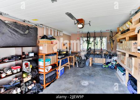 Squamish, British Columbia, Kanada - 2. April 2016: Eine organisierte Garage im Innenbereich, gefüllt mit persönlichem Zeug und Müll auf Regalen gestapelt. Stockfoto