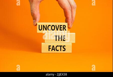Entdecken Sie das Facts-Symbol. Concept Words Entdecke die Fakten auf Holzblöcken auf einem schönen orangen Tisch orangenen Hintergrund. Geschäftsmann Hand. Unternehmen A Stockfoto