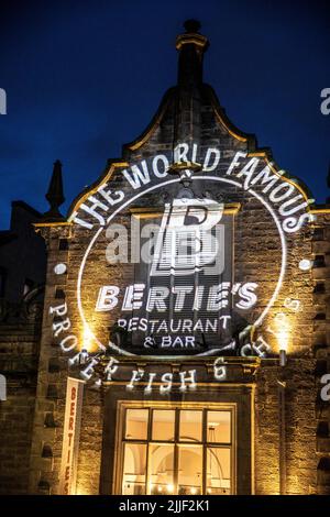 Victoria Street Edinburgh bei Nacht und weltberühmtes Berties Fish and Chips Restaurant beleuchtet, Schottland, Großbritannien, Sommer 2022 Stockfoto