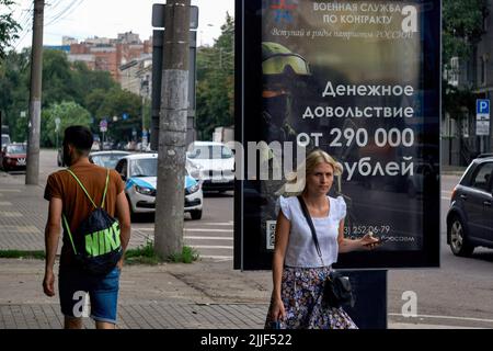 Woronesch, Russland. 25.. Juli 2022. Fußgänger gehen an einer Plakatwand vorbei, die den Militärdienst unter einem Vertrag an einem typischen Sommertag in Woronesch annonciert. Kredit: SOPA Images Limited/Alamy Live Nachrichten Stockfoto