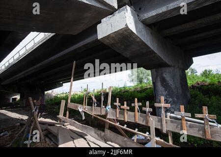 Kreuze, die an der zerstörten Brücke über den Fluss Irpin angebracht wurden, um an die Opfer der Evakuierung aus den von russischen Truppen besetzten Städten in Kiew zu erinnern. Russland marschierte am 24. Februar 2022 in die Ukraine ein. Stockfoto