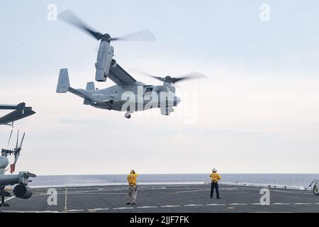 220725-N-XB010-1004 SÜDCHINESISCHES MEER (25. Juli 2022) ein MV-22B Fischadler hebt nach der Lieferung und dem Personal von dem nach vorne eingesetzten Amphibientransportschiff USS New Orleans (LPD 18) Flugdeck ab. New Orleans, Teil der Amphibious Ready Group von Tripolis, ist zusammen mit der Marine Expeditionary Unit von 31. im Verantwortungsbereich der US-Flotte von 7. tätig, um die Interoperabilität mit Verbündeten und Partnern zu verbessern und als einsatzbereite Einsatztruppe zur Verteidigung von Frieden und Stabilität in der Indo-Pazifik-Region zu dienen. (USA Navy Foto von Mass Communication Specialist 1. Class Desmond Parks) Stockfoto