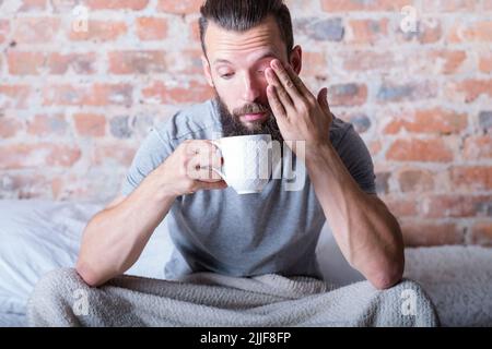 montagmorgen Schläfrigkeit Mann Bett Tasse abgelenkt Stockfoto