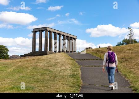 Weibliche Touristin, Model-Release, geht an einem Sommertag zum National Monument auf dem Calton Hill in Edinburgh, Edinburgh, Schottland, Großbritannien Stockfoto