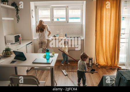 Familie aus drei Personen, die gemeinsam Hausarbeit leisten Stockfoto