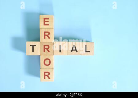 Versuch-und-Fehler-Konzept. Holzblock Kreuzworträtsel flach lag auf blauem Hintergrund. Stockfoto