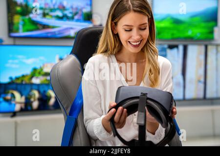 Glückliche Frau mit VR-Brille und genießen Virtual-Reality-Spiel. Technologiesimulation People-Konzept Stockfoto