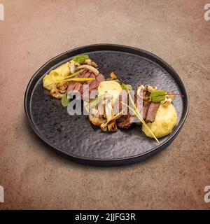 Rindersteak in Scheiben, serviert mit Kartoffelpüree und gegrillten Pilzen Stockfoto