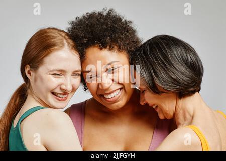 Ein ehrliches Porträt von drei verschiedenen jungen Frauen, die glücklich miteinander lachen Stockfoto