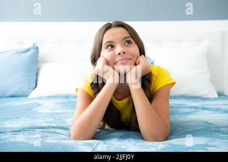 Teenager Kind Mädchen Tagträumen im Bett, träumen Kinder Konzept. Kind liegt auf dem Bett, Stockfoto