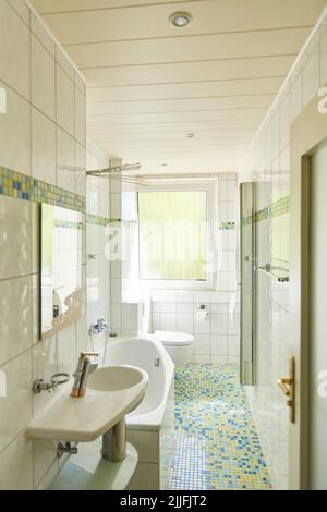 Kleines, kleines, helles Badezimmer mit Badewanne in einem Apartment Stockfoto